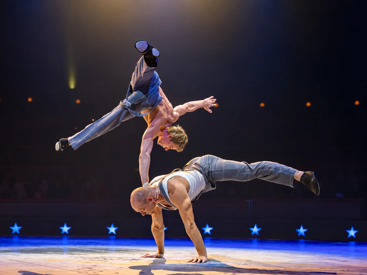 Sculptural two-level balance under warm stage lighting