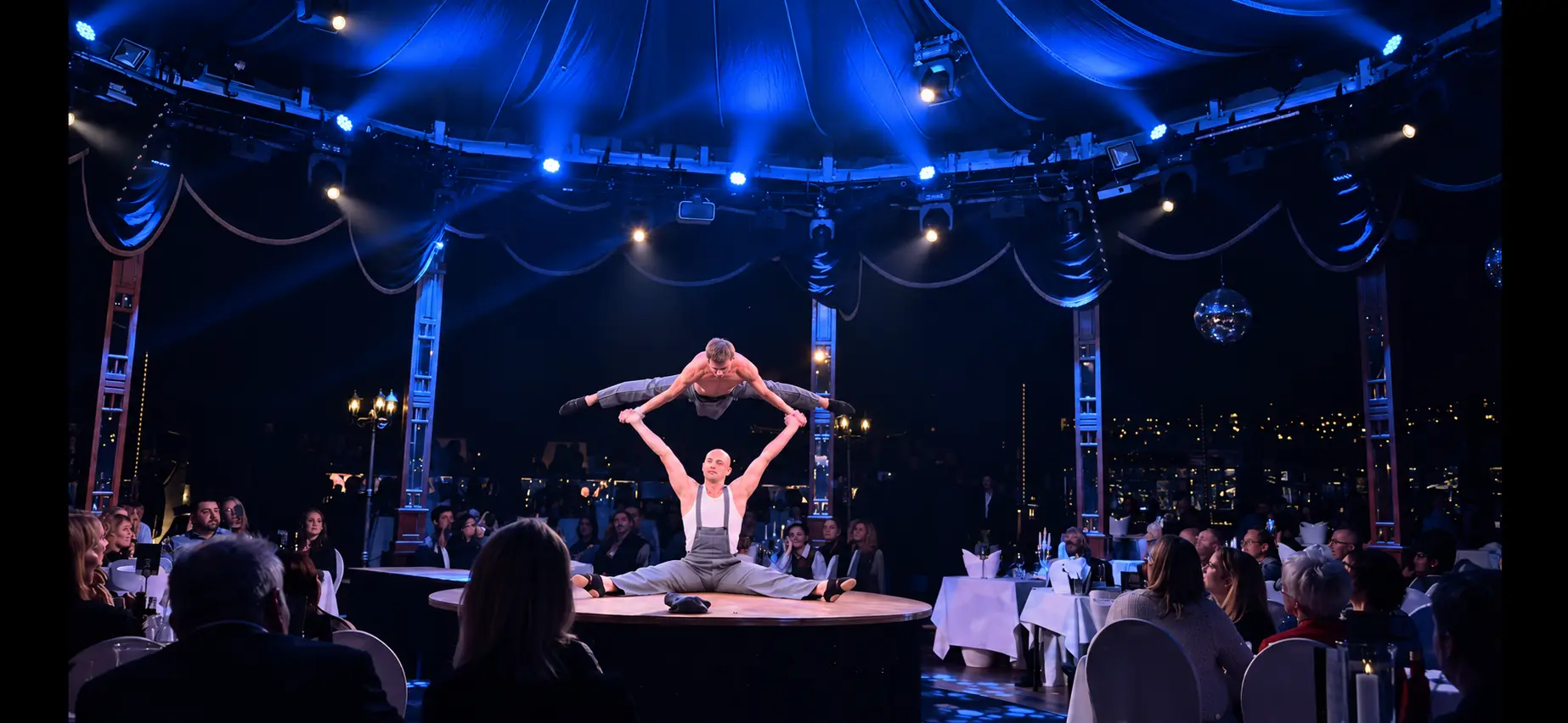 Wide split-balance finale surrounded by the audience